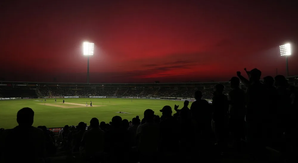 Cricket stadium at night under floodlights